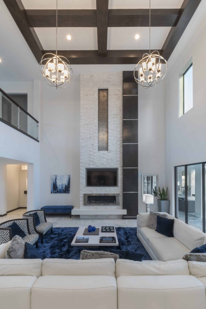 The living room of The Design Tourist's Florida Modern home features two large globe lighting fixtures that fill just enough space in two-story room without overwhelming. The white sofa sectional visually defines the perimeter of the living space. 