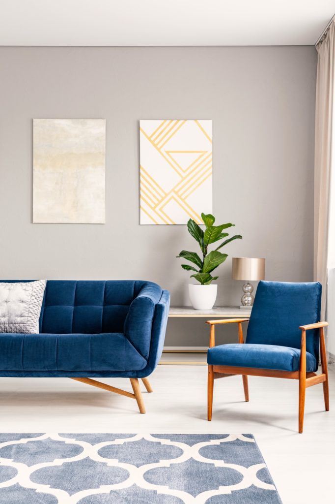 Two modern art paintings hanging on wall in real photo of bright
