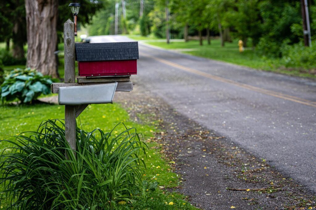 a traditional American mailbox on the side of a village road