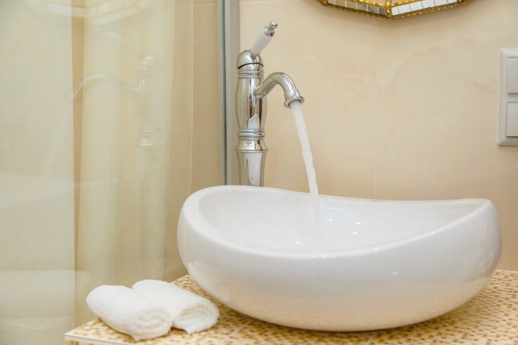 Water pours out of the tap. Modern bathroom interior.