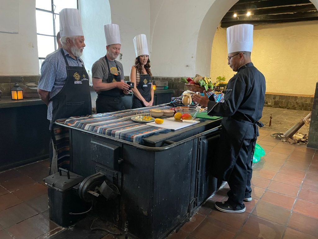 Chef teaching guests in chef hats to make ceviche in the San Diego Convent kitchen, Quito