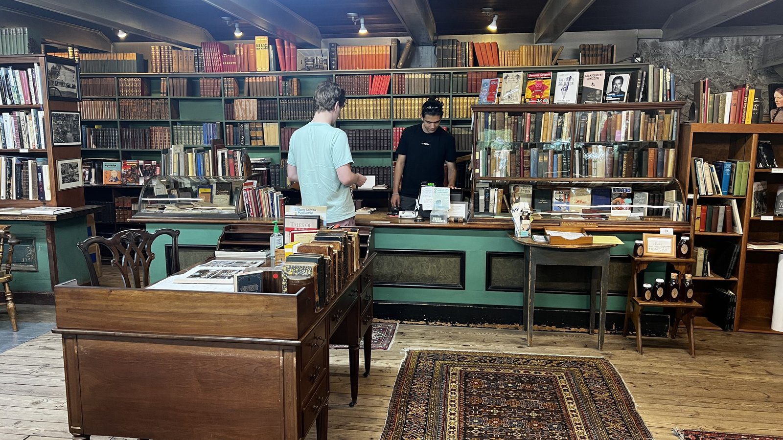 Interior of Baldwin’s Book Barn, one of Brandywine Valley’s best bookstores, showing a customer at the front counter surrounded by rare and vintage books.