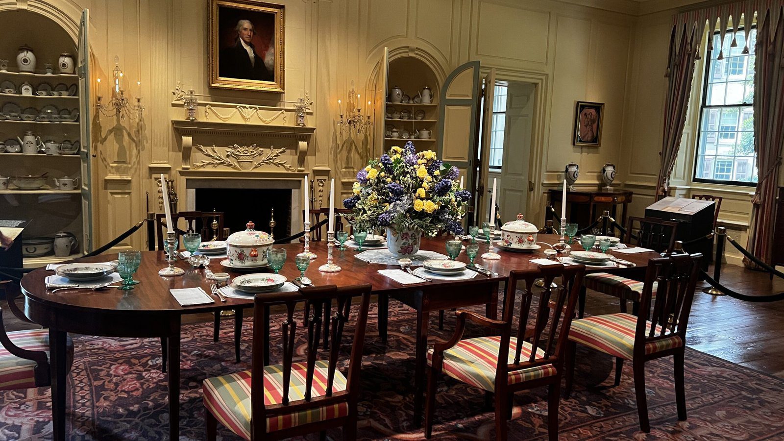 Formal dining room at Winterthur set with fine china, fresh floral centerpiece, and colonial-era decor