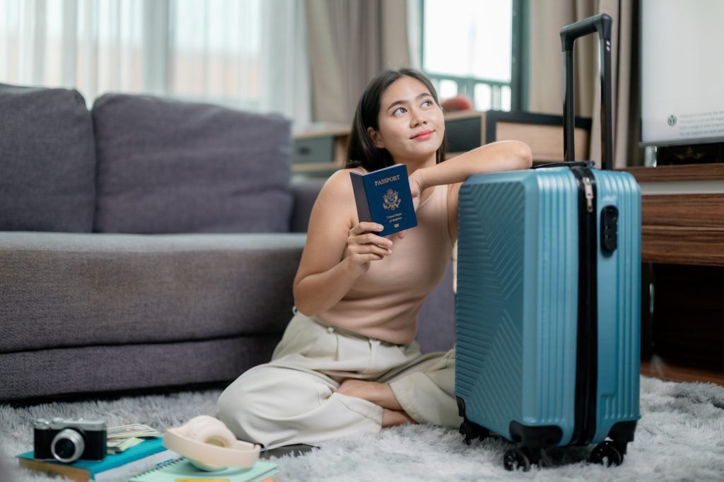 Young woman holding a United States passport and dreaming of her next trip abroad