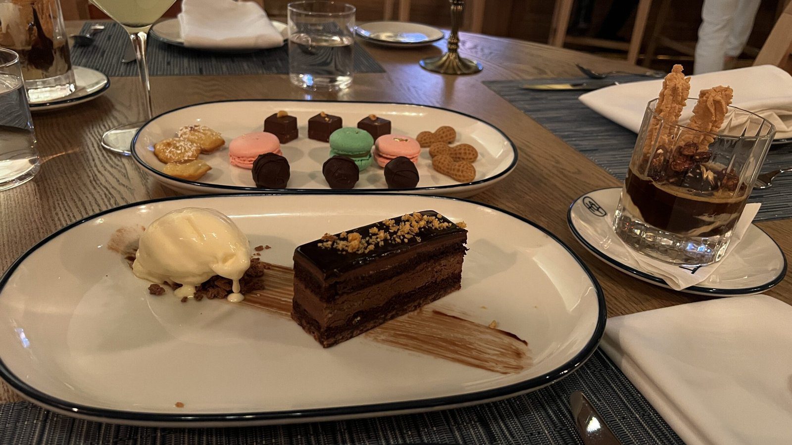 Dessert spread at Latuli with chocolate cake topped with nuts and ice cream, assorted macarons, truffles, and an affogato.