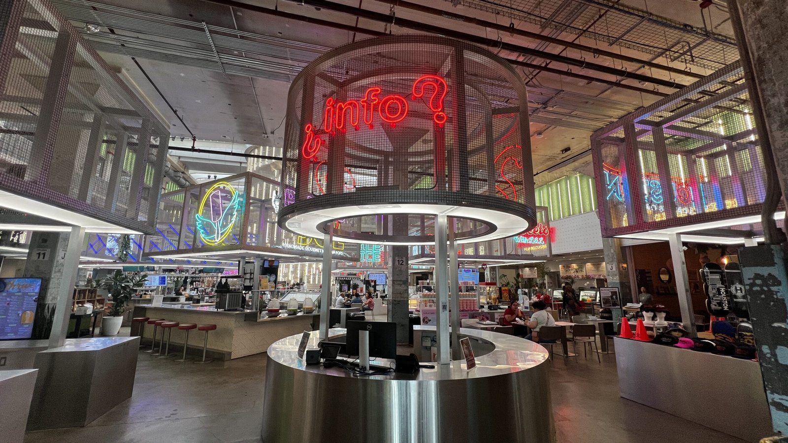 Futuristic interior of POST Houston food hall featuring neon signage, modern architecture, and international food stalls.