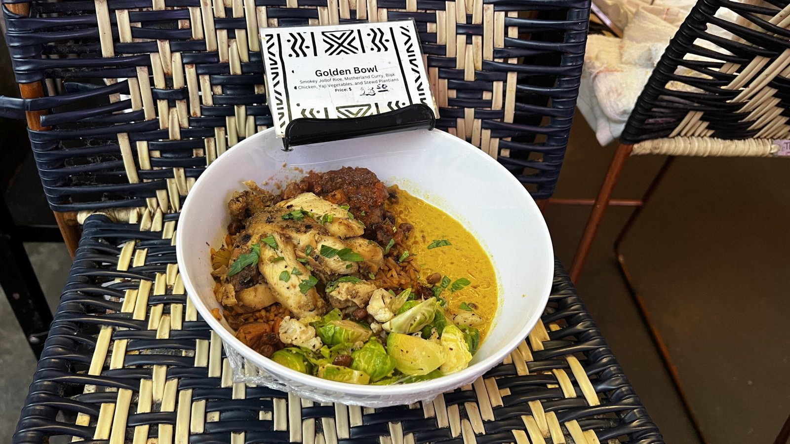 Chopnblok’s Golden Bowl at POST Houston, filled with smoky jollof jambalaya, grilled chicken, sausage, curry, plantains, and spiced vegetables.