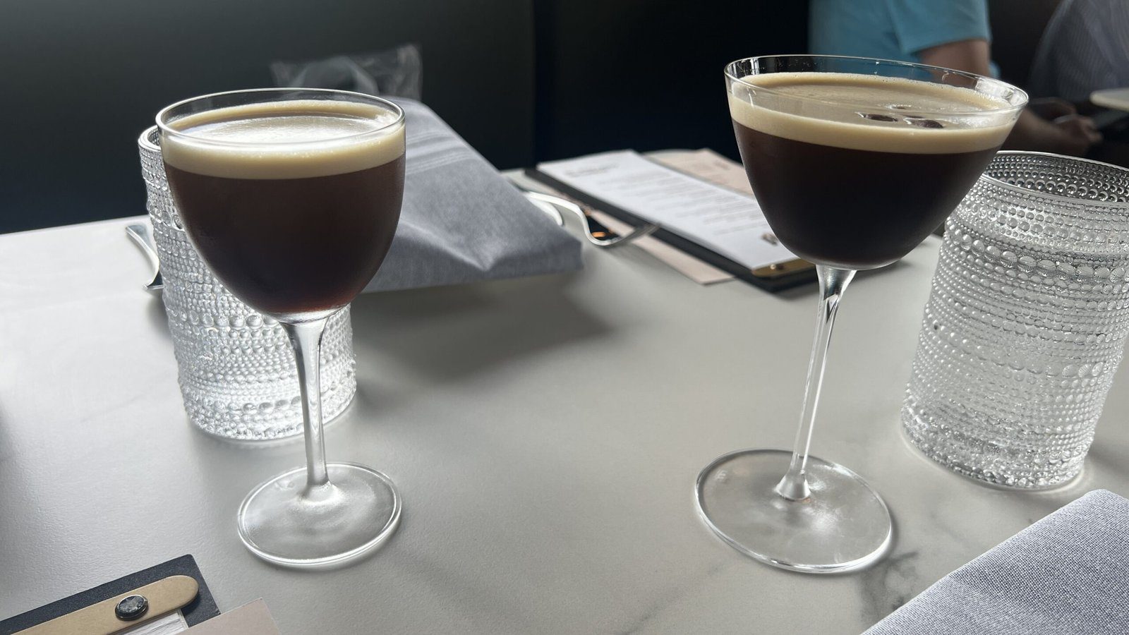 Two espresso martinis served in coupe glasses at Maven Coffee + Cocktails in Houston.