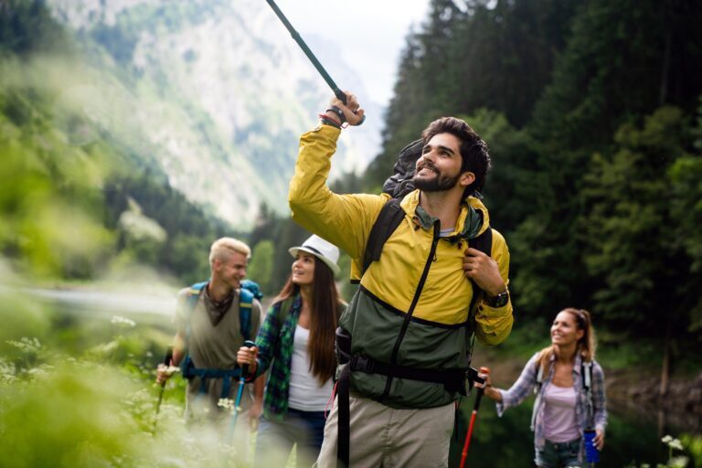Group of happy fit friends hiking, trekking together outdoor nature