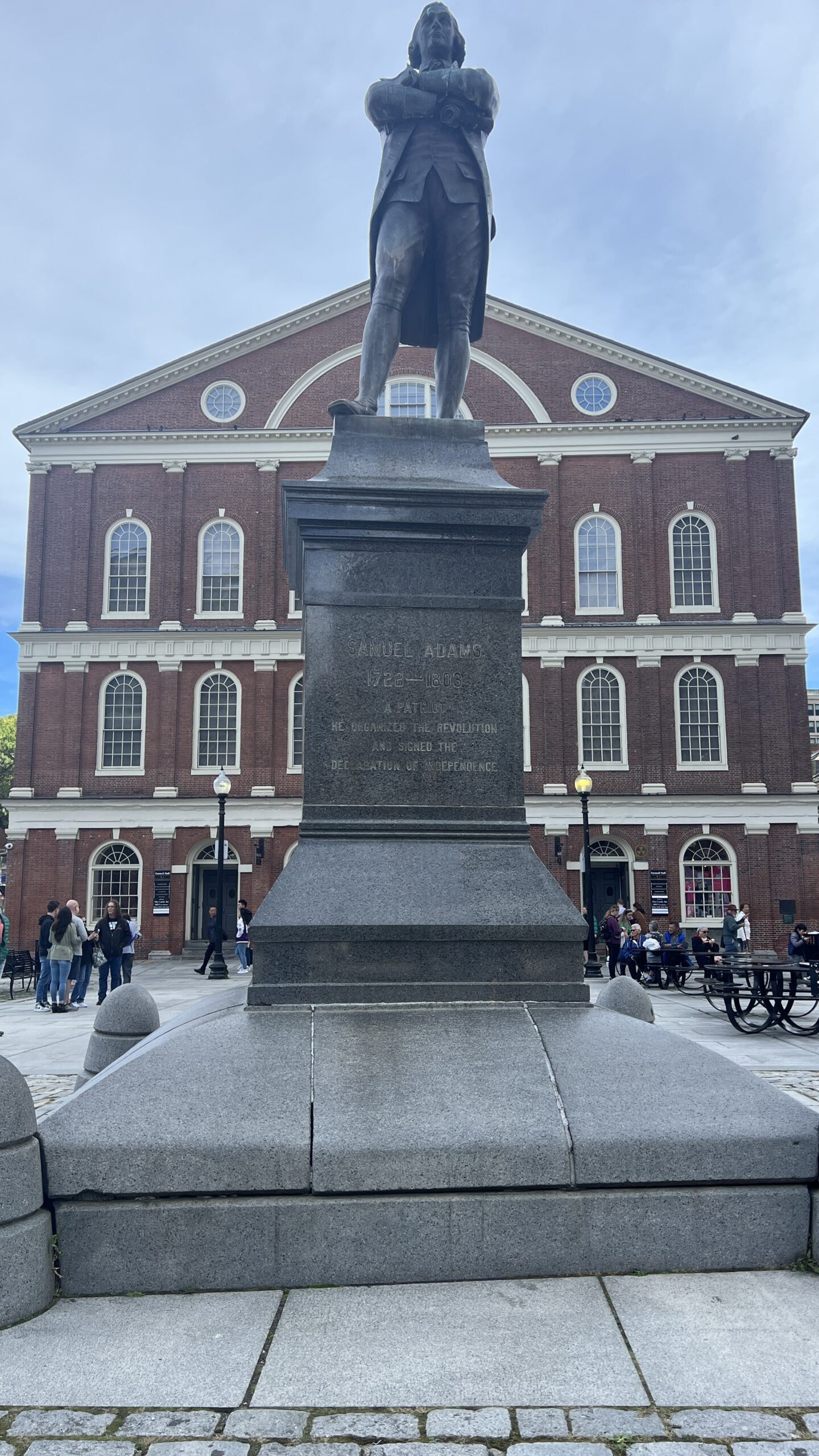 Close-up of bronze equestrian statue showing Paul Revere on horseback from below, with name engraved on granite pedestal base