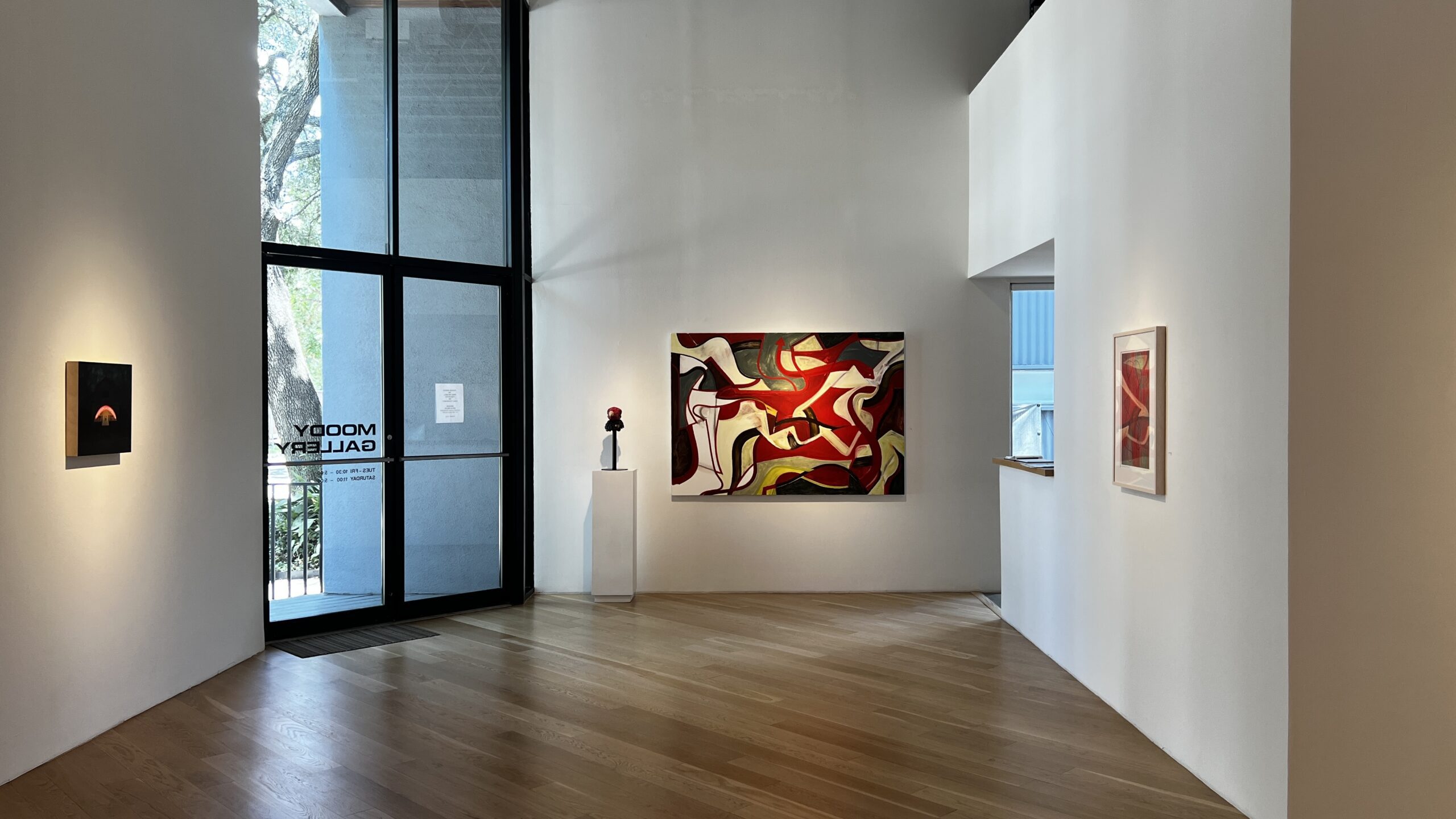 Contemporary gallery interior with white walls, wooden floors, and modern artworks at Betty Moody Gallery in Montrose.